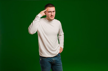 young handsome man feeling confused and puzzled, showing you are insane, crazy or out of your mind...