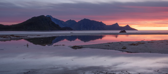  red sunset on a paradise beach Haukland with white sand, and mountains the Lofoten Islands in...