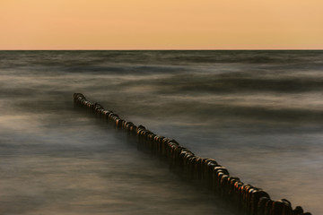 Wooden breakwater at sunset on the Baltic Sea