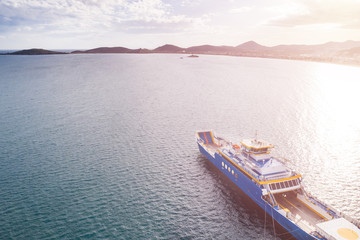 Ferry boat in the sea during sunset, aerial view with copy space.
