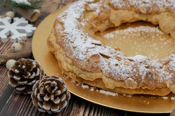 French dessert paris-brest whit sugar powder and almonds on the golden plate