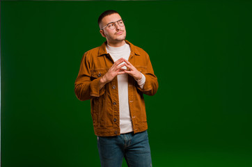 young handsome man scheming and conspiring, thinking devious tricks and cheats, cunning and...