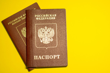 Russian national and international passports and russian moneys, document and travel concept, flat lay at the yellow background with copyspace for a text