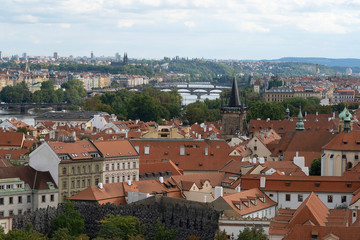 Fototapeta na wymiar Red terracotta roofs in the city of Prague. View of the city from above, in the distance the tower, sunny day. A beautiful city for leisure and travel in Europe.