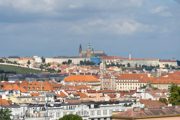 Fototapeta na wymiar Red roofs in the city of Prague. View of the palace, blue sky, sunny day. A beautiful city for leisure and travel.