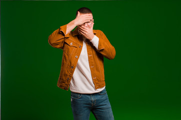 young handsome man covering face with both hands saying no to the camera! refusing pictures or...