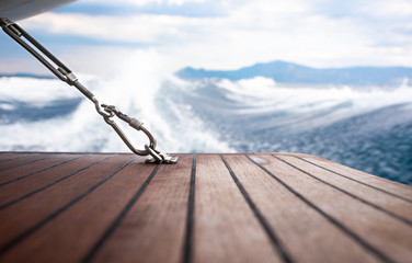 Close up carabiner attached to wooden floor on yacht.