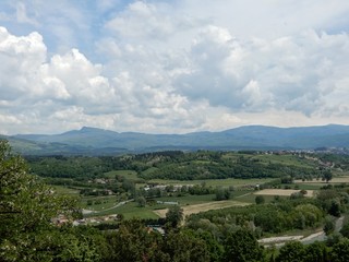 Fototapeta na wymiar Campagna toscana, vista di Poppi in Casentino strada e campi contivati panorama