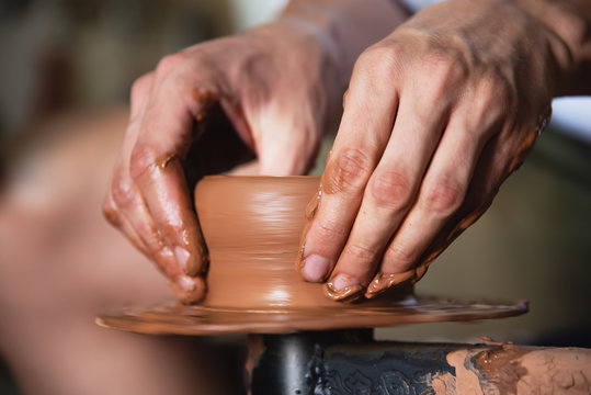 Close up male hands making pottery.