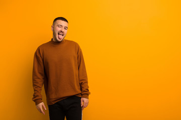 young handsome man with cheerful, carefree, rebellious attitude, joking and sticking tongue out,...