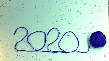  New Year 2020 blue festive background with thread tied with a blue ribbon. New Year 2020 concept. Selective focus, defocused view.