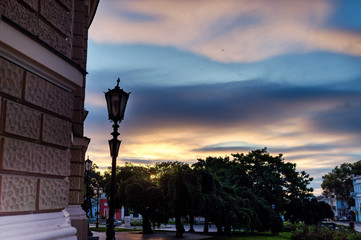 Fototapeta premium Piękne miasto o zachodzie słońca. Oszałamiające kolorowe niebo nad placem. Selektywna ostrość.