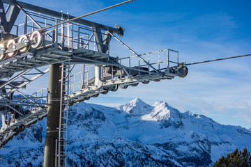 Ski lift detail with alpine snowy peaks in distance, Obertauern, Austria, Europe