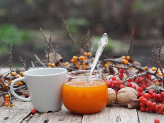 rowan-sea-buckthorn branches and sea-buckthorn jam on a wooden background