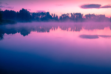 Magical sunrise over the lake with a beautiful reflection on the water. Calm lake in the early morning. Natural landscape
