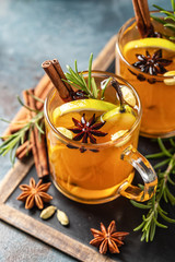 Hot drink cocktail for New Year, Christmas, winter or autumn holidays..Toddy. Mulled pear cider or spiced tea or grog with lemon, pear, cinnamon, anise, cardamom, rosemary. - 305071551