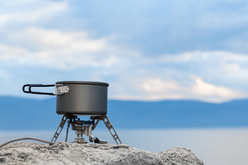 Tourist portable gas stove for preparing hot dishes and tea in the fresh air. A portable stove for outdoor activities, usually used for camping, hiking and other outdoor activities. Copy space