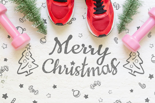 Christmas healthy acive lifestyle flat lay composition with sneakers, dumbbells, christmas tree on grunge white wood  background. Merry Christmas and Happy new year background healthy lifestyle