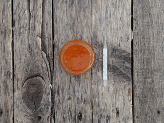 sea ​​buckthorn jam on a wooden rustic table with a medical thermometer