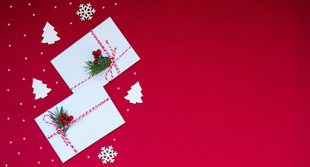 Christmas and new year design with spruce, vintage wooden decoration and the envelope on red background. Top view space for you text.