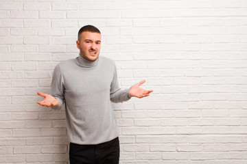 young handsome man feeling clueless and confused, not sure which choice or option to pick,...