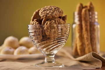 Three types of cookies in beige tones on a napkin in a plate and in a jar. The concept of a rustic style