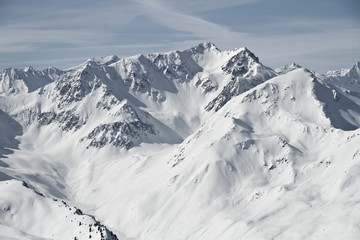 Obraz premium Blick von der Axamer Lizum in Tirol auf die schneebedeckten Berge und Gipfel. Neuschnee im Winter. Lawinen Gefahr am Berg
