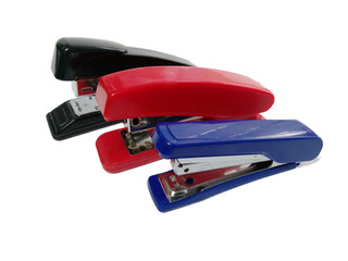 Three colored blue red and black staplers on a white background. isolate. office supplies.
