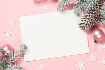 Christmas greeting card with empty blank sheet, fir tree and decorations on pink.