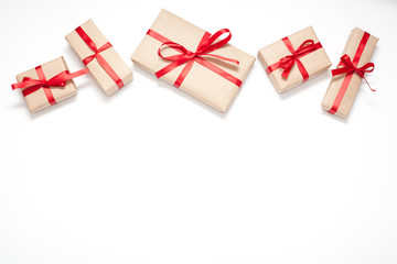 Fototapeta na wymiar Gifts isolated on white background, Packed in brown paper and decorated with red ribbon with bow, there is room for lettering. Concept surprises and gifts for loved ones.