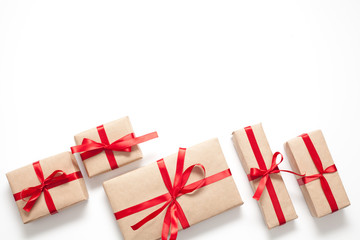 Gifts isolated on white background, Packed in brown paper and decorated with red ribbon with bow, there is room for lettering. Concept surprises and gifts for loved ones.