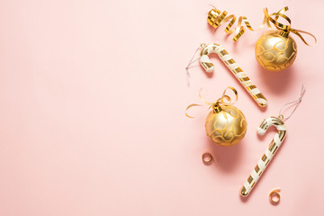 Christmas background for text, pink color, decorated with gold Christmas toys, bows and candies....