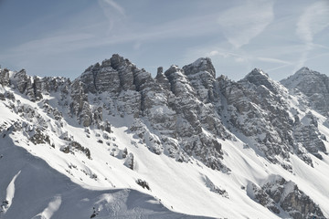 Ski Tour in der Axamer Lizum in Tirol mit Spuren und schneebedeckten Bergen zum Gipfel. Neuschnee im Winter. Steile Berghänge