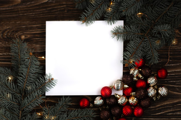 Paper card note with Christmas tree branches on the wooden backgraund. New Year concept