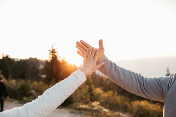 Close up view of young couple joining hands. Love and partnership goals. Bride and groom holding their hand on wedding day.