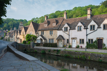 CASTLE COMBE, COTSWOLDS, UK - MAY 26, 2018: Street view of old riverside cottages in the picturesque Castle Combe Village, Cotswolds, Wiltshire, England - UK