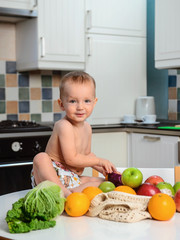 Cute baby at the table with fruits and vegetables. Healthy child nutrition. Fruits and vegetables  in ecologikal bag.