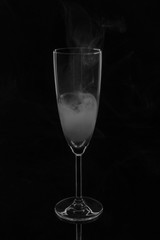 An empty glass glass filled with smoke on a dark background.
