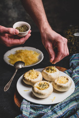 Sprinkling spices on the stuffed button mushrooms