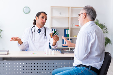 Obraz premium Old man visiting young male doctor