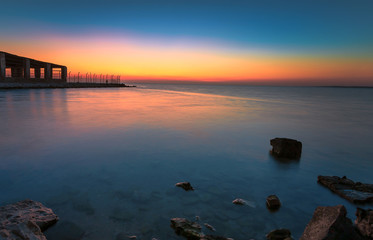 Dramatic sunrise with silky water view in Al uqair ruined fort sea side Saudi Arabia.