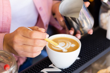 Professional barista girl makes a bear pattern on latte in a coffee shop, a woman draws a bear on coffee. Close-up
