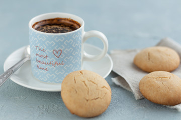 A mug of coffee on a saucer with homemade rice cookies.