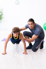 Fototapeta na wymiar Young father and his son doing exercises