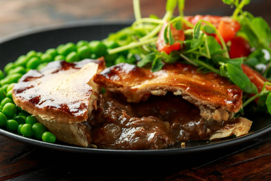 Beef steak pies with rich onion gravy served with sweet peas and salad - Powered by Adobe
