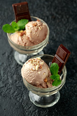 Chocolate Ice Cream with dark chocolate bars and hazelnuts in a glass bowl