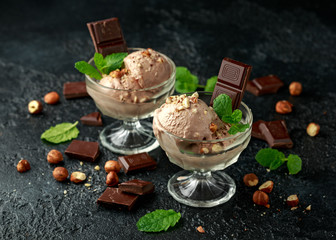Chocolate Ice Cream with dark chocolate bars and hazelnuts in a glass bowl