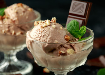 Chocolate Ice Cream with dark chocolate bars and hazelnuts in a glass bowl