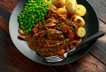 Classic beef stroganoff servei with boiled baby potato and sweet peas