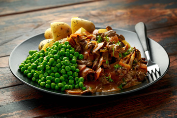 Classic beef stroganoff servei with boiled baby potato and sweet peas